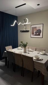 een eetkamer met een tafel met stoelen en een licht bij شاليهات لورين الفندقية in Taif