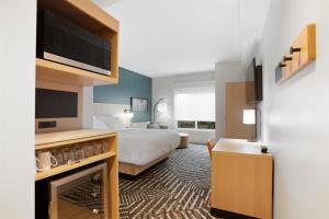 a hotel room with a bed and a flat screen tv at Hyatt House Thunder Bay in Thunder Bay