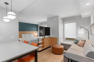 a hotel room with a bed and a couch at Hyatt House Thunder Bay in Thunder Bay