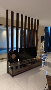 een woonkamer met een flatscreen-tv op een entertainmentcentrum bij شاليهات لورين الفندقية in Taif
