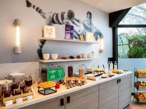 a breakfast buffet with food on a counter at ibis Styles Colombes Paris Ouest (Ouverture Octobre 2025) in Colombes