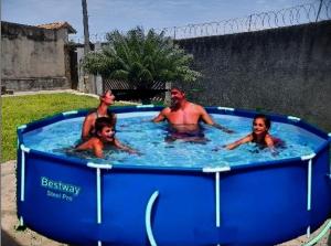 eine Gruppe von Menschen in einem Whirlpool in der Unterkunft Peruíbe - Oasis - Casa espaçosa, lugar tranquilo in Peruíbe