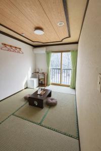a living room with a table and a large window at 雪场缆车站旁-START HOUSE PIAA-Ski IN Ski OUT in Minami Uonuma