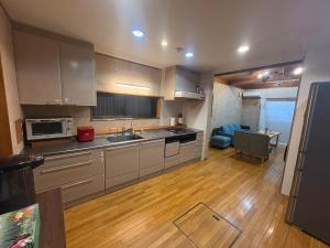 a kitchen with a sink and a microwave at 最大10名 源泉掛け流し露天風呂付き一棟貸しNagasima Private Villa in Genroku