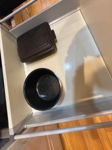 a container with a black lid on top of a refrigerator at 最大10名 源泉掛け流し露天風呂付き一棟貸しNagasima Private Villa in Genroku