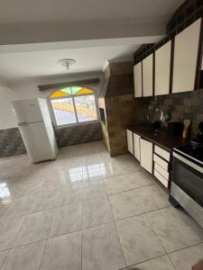 eine große Küche mit Fenster und Fliesenboden in der Unterkunft Pousada próximo ao hospital regional in São José + 5 Fotos