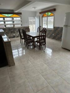 ein Esszimmer mit einem Tisch und Stühlen sowie einem Kühlschrank in der Unterkunft Pousada próximo ao hospital regional in São José