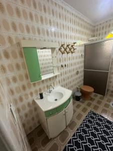ein Badezimmer mit Waschbecken und Spiegel in der Unterkunft Pousada próximo ao hospital regional in São José