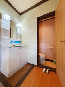 een badkamer met een deur en twee paar schoenen bij 雪场缆车站旁-START HOUSE PIAA-Ski IN Ski OUT in Minami Uonuma