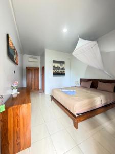 a bedroom with a large bed with a large roof at Manta Manta Guesthouse in Labuan Bajo