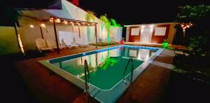 una piscina davanti a una casa di notte di Coralma a La Floresta