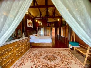 een slaapkamer met een bed in een kamer met gordijnen bij Elephant House and Pool Villas 