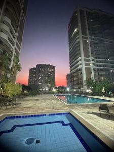 een zwembad in het midden van een stad 's nachts bij Condomínio Four Seasons Residence Service in Rio de Janeiro