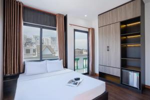 a bedroom with a bed and a large window at ELC Luxury Đà Lạt in Da Lat