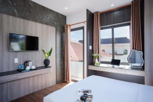 a hotel room with a bed and a window at ELC Luxury Đà Lạt in Da Lat