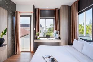 a bedroom with a bed and a large window at ELC Luxury Đà Lạt in Da Lat
