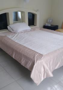 a large bed with a white bedspread on it at Jamaica Beach in Tower Isle