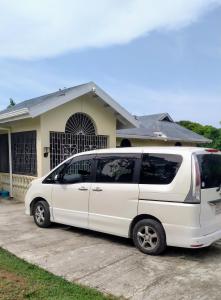 a white van parked in front of a house at Jamaica Beach in Tower Isle
