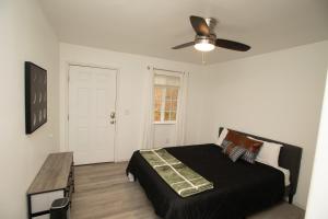 a bedroom with a black bed and a ceiling fan at Yosemite Gateway home in Groveland in Groveland