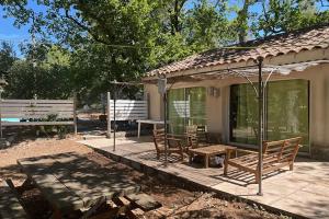 un portico di una casa con sedie e un tavolo di Gîte du Jonquas a Velleron