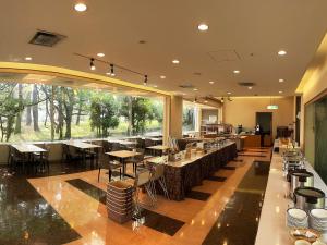 a restaurant with tables and chairs and a large window at Hotel Crown Palais Kitakyushu in Kitakyushu