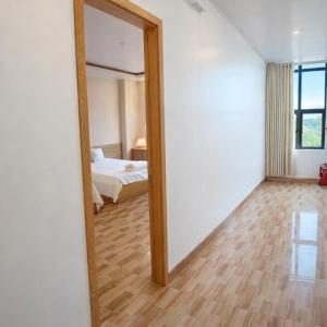 een spiegel in een kamer met een bed en een slaapkamer bij Hưng Phát Hotel - Gần Bến Xe Hà Tĩnh in Ha Tinh