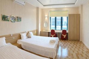 een hotelkamer met twee bedden en een raam bij Hưng Phát Hotel - Gần Bến Xe Hà Tĩnh in Ha Tinh +22 foto's