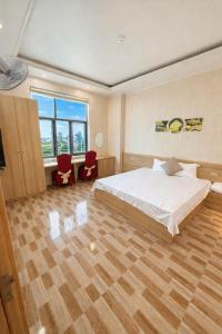 een slaapkamer met een bed, een bureau en een raam bij Hưng Phát Hotel - Gần Bến Xe Hà Tĩnh in Ha Tinh