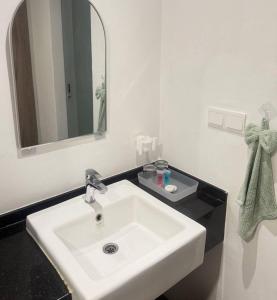 a bathroom with a white sink and a mirror at AbahHomeStudio Tunjung in Kota Bharu