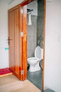 een open deur naar een badkamer met een toilet bij BAMBOO Shack & BAMBOO Cabin in Bukittinggi