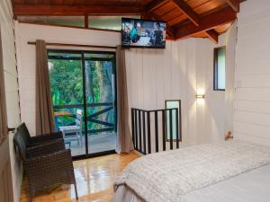 een slaapkamer met een bed en een tv aan de muur bij Nido de Montaña in Fraijanes +17 foto's