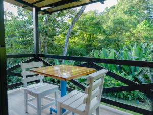 einen Tisch und Stühle auf der Veranda eines Hauses in der Unterkunft Nido de Montaña in Alajuela