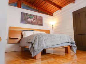 een slaapkamer met een bed met een houten hoofdeinde bij Nido de Montaña in Alajuela