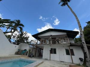 a house with a balcony and a swimming pool at Tribal Xperience Guesthouse in San Vicente