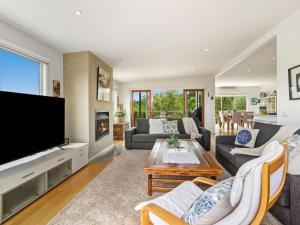 een woonkamer met een grote flatscreen-tv bij Olive Tree Retreat in Tootgarook