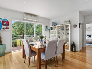 een eetkamer met een tafel en witte stoelen bij Olive Tree Retreat in Tootgarook