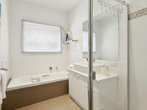 een witte badkamer met een bad en een wastafel bij Olive Tree Retreat in Tootgarook +11 foto's