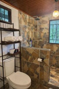 bagno con servizi igienici e parete in pietra di Villa en la naturaleza  Altre 5 foto