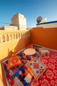 a room with a table and a rug on a balcony at Entire Guesthouse with Private Rooftop in Taghazout
