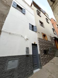 a white building with a door on the side of it at Entire Guesthouse with Private Rooftop in Taghazout +6 photos