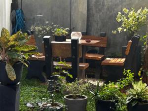 een tuin met een tafel en stoelen en potplanten bij A&J Rest House 