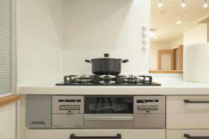 a kitchen with a stove with a pot on it at Peace and Harmony House Rongsheng in Nagoya