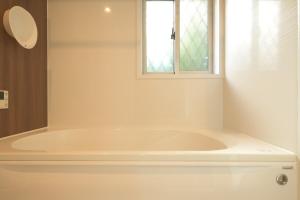 a white bath tub in a bathroom with a window at Peace and Harmony House Rongsheng in Nagoya +30 photos
