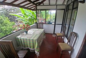 a balcony with a table and chairs and a window at Kumari villa in Weligama