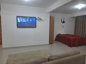 een woonkamer met een flatscreen-tv aan de muur bij Studio Litorâneo para Relaxar in Governador Celso Ramos