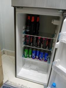 einen offenen Kühlschrank mit Getränken und Limonaden in der Unterkunft Blue star inn in Al Hamra