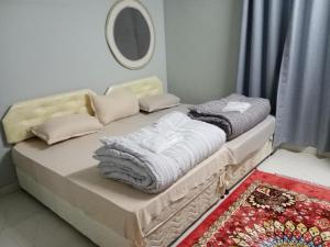 ein Bett mit Handtüchern und Kissen darauf in einem Zimmer in der Unterkunft Blue star inn in Al Hamra