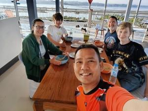 een groep mensen die rond een houten tafel zitten bij ชมวิว บึงโขหลง in Ban Don Klang +47 foto's