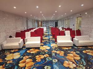 Una habitación con sillas rojas y una alfombra floral. en Hotel Omkar Palace, en Ayodhya
