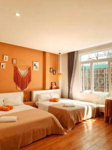 a bedroom with two beds and a window at Gin House Đà Lạt in Da Lat